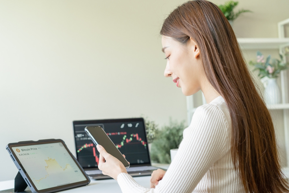 ผู้หญิงกำลังดูว่าจะเทรดหุ้นแอปไหนดี